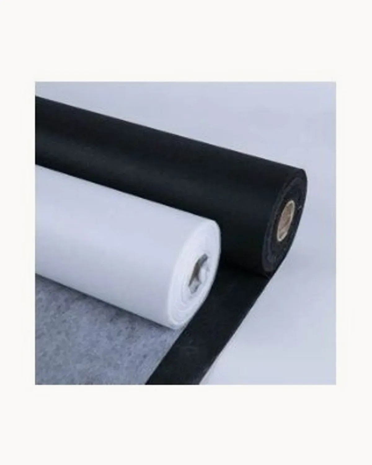 Rolls of white, grey and black fusible interfacing