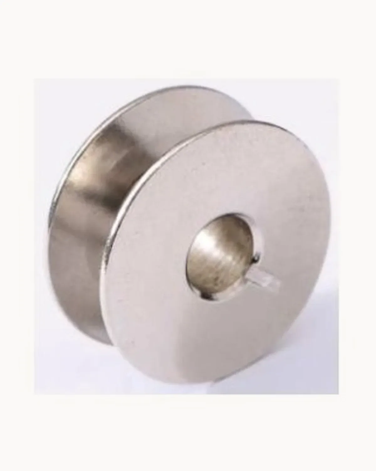 A deep industrial piqueuse bobbin in polished steel