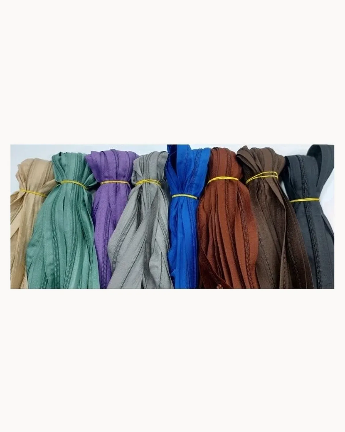 Bundles of nylon zips in sand, green, purple, grey, blue, rust and brown
