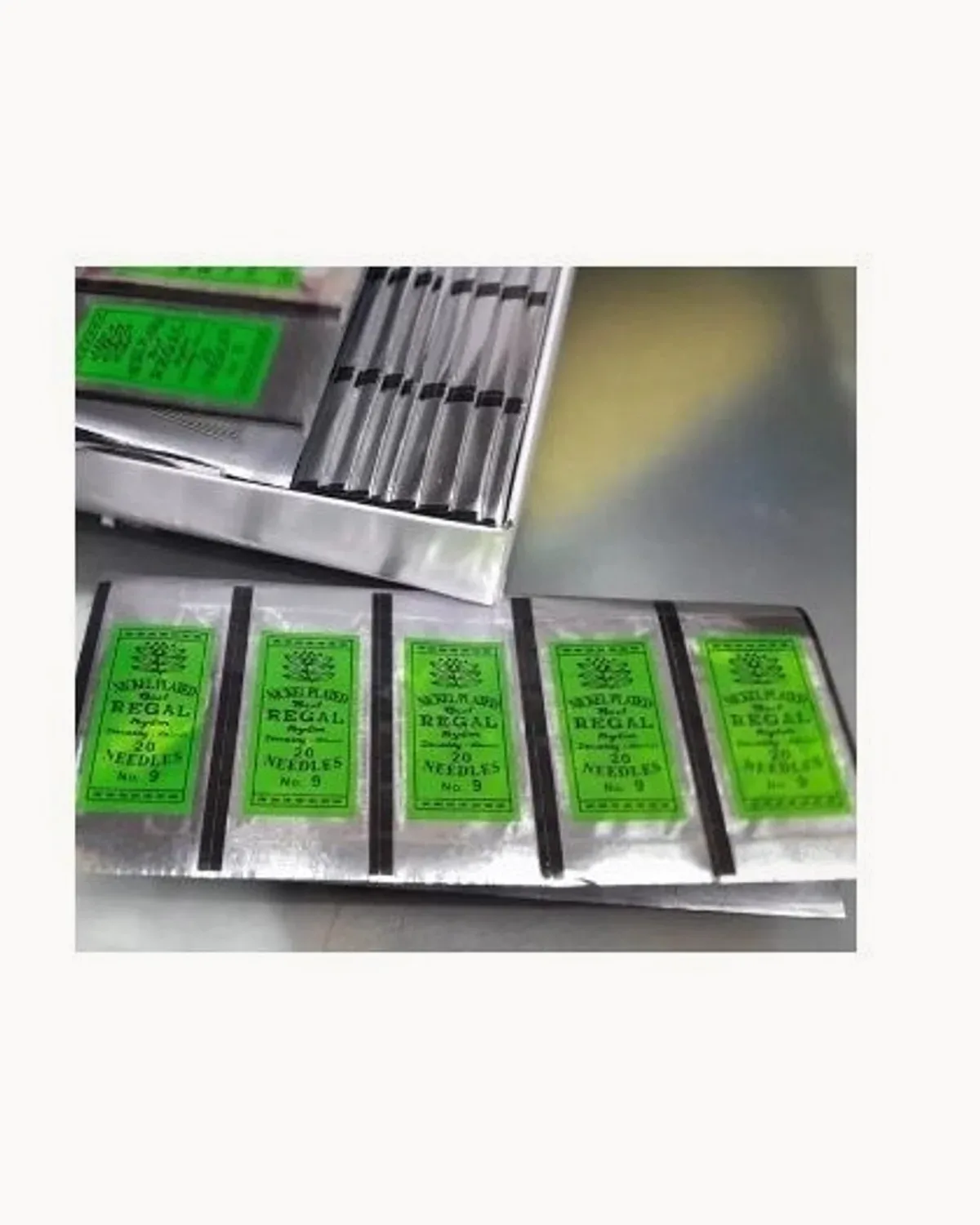 Green-labelled packets of Regal No.9 randa needles in an open tray